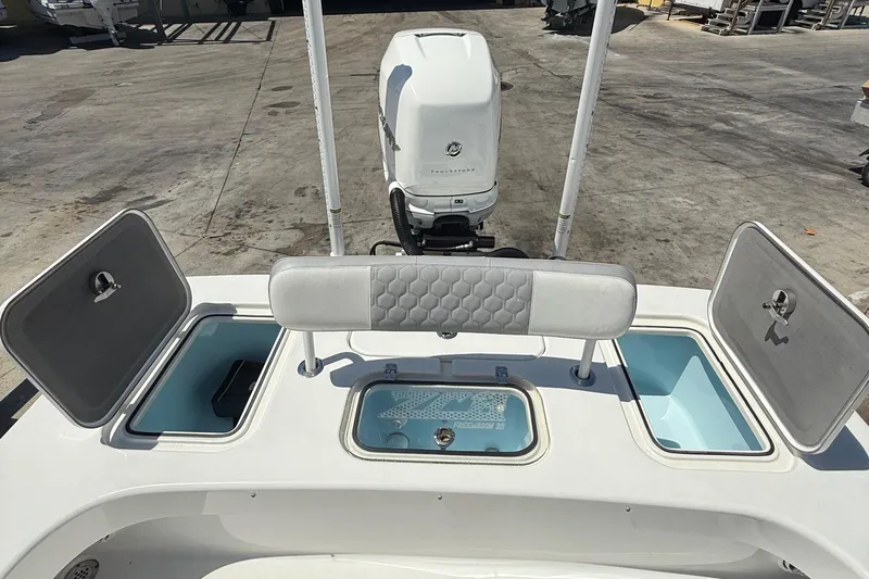 Slide: The Image of 2022 ZCB 26 Freemason boat with open storage compartments and outboard motor. - 9