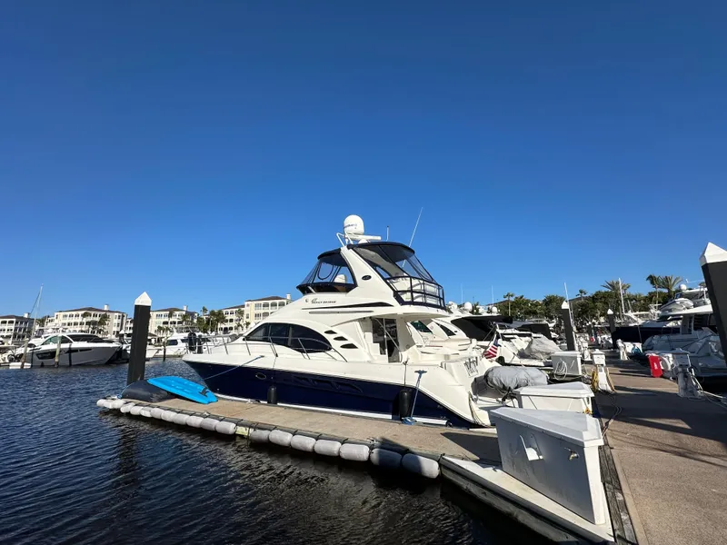 Slide: The Image of 2005 Sea Ray 420 Sedan Bridge yacht docked at marina under clear blue sky. - 0