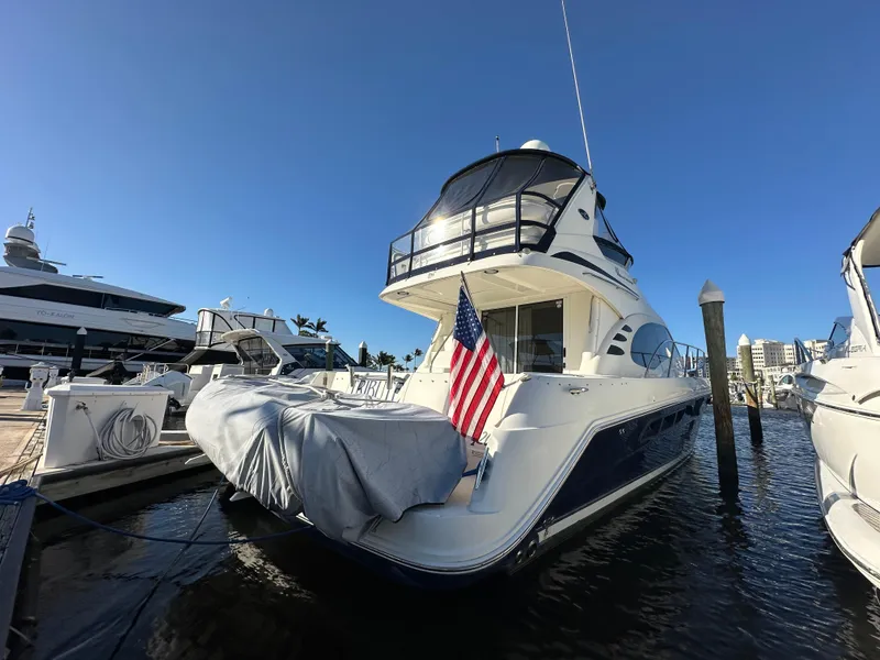 Slide: The Image of 2005 Sea Ray 420 Sedan Bridge yacht docked with American flag displayed. - 1