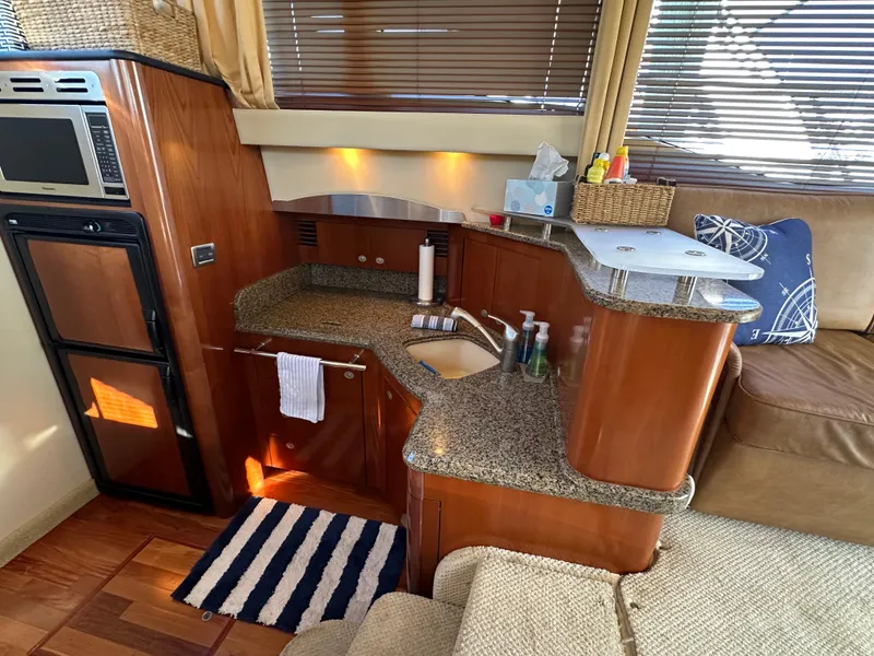 Slide: The Image of Interior of 2005 Sea Ray 420 Sedan Bridge with modern kitchen and cozy seating area. - 14