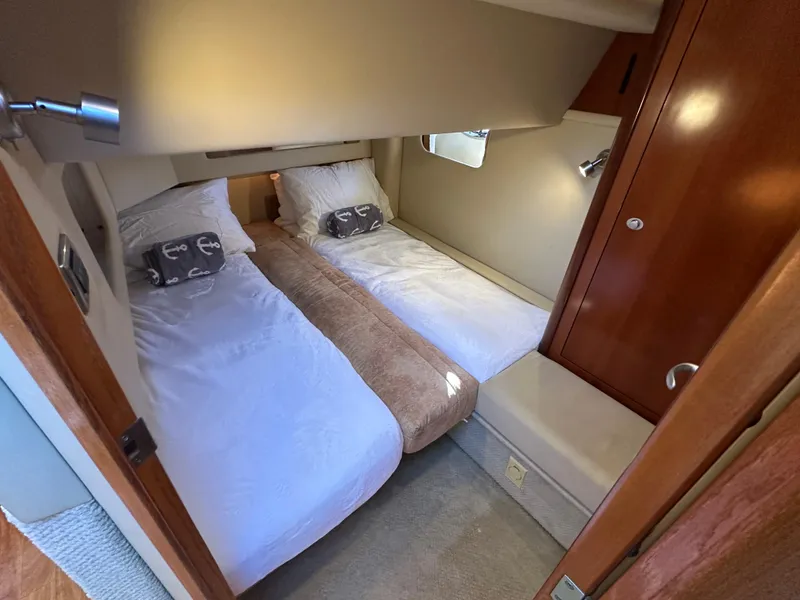 Slide: The Image of 2005 Sea Ray 420 Sedan Bridge cabin with twin beds and wooden interior. - 17