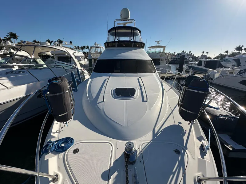 Slide: The Image of 2005 Sea Ray 420 Sedan Bridge yacht docked at marina under clear blue sky. - 4