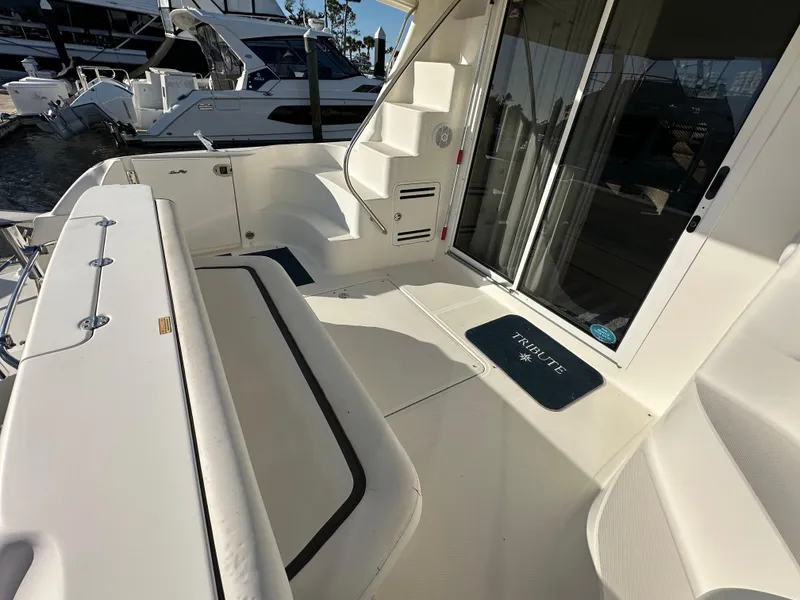 Slide: The Image of 2005 Sea Ray 420 Sedan Bridge yacht deck with seating and stairs, docked at marina. - 5