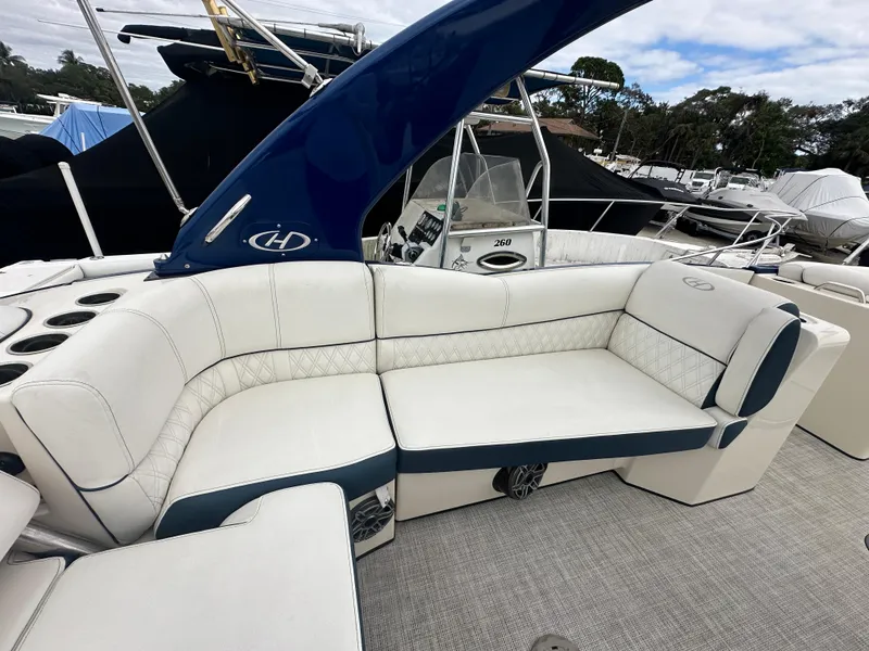 Slide: The Image of 2022 Harris Crowne SL 250 boat with luxurious white seating and blue accents. - 15