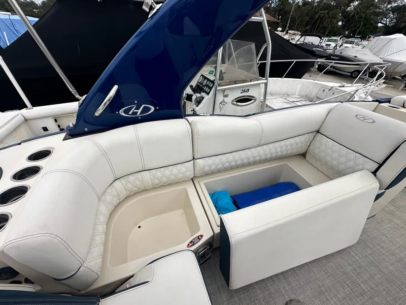 Slide: The Image of 2022 Harris Crowne SL 250 boat interior with white seating and storage compartment. - 16