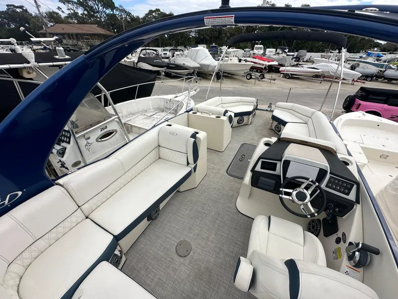 Slide: The Image of 2022 Harris Crowne SL 250 boat interior with luxurious seating and modern dashboard. - 18