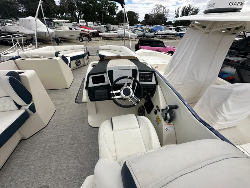 Slide: The Image of 2022 Harris Crowne SL 250 boat interior with steering wheel and seating area. - 19