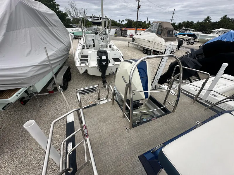 Slide: The Image of 2022 Harris Crowne SL 250 pontoon boat in a marina, surrounded by other boats. - 2
