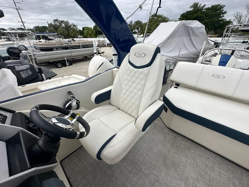 Slide: The Image of 2022 Harris Crowne SL 250 boat interior with luxurious seating and steering wheel. - 20