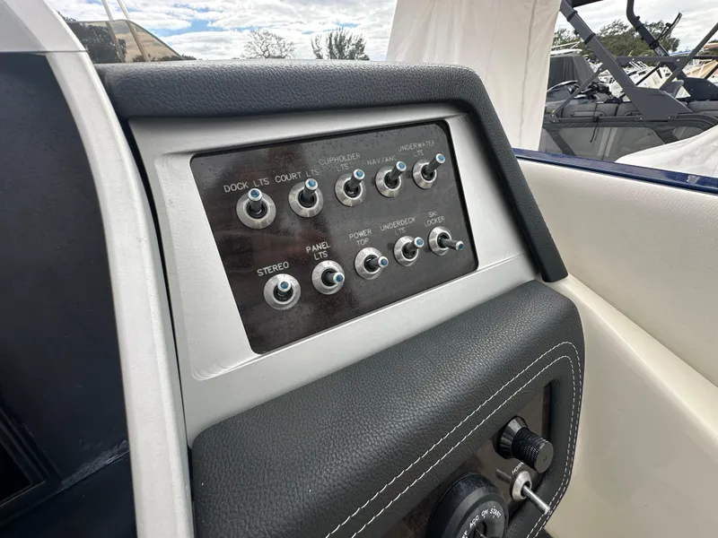 Slide: The Image of Control panel of a 2022 Harris Crowne SL 250 boat with various switches. - 25