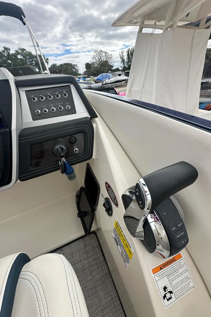 Slide: The Image of 2022 Harris Crowne SL 250 boat dashboard with control panel and throttle lever. - 26