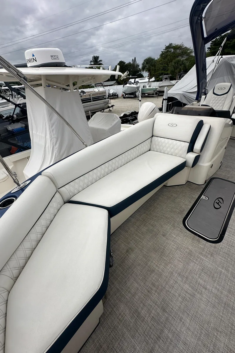 Slide: The Image of 2022 Harris Crowne SL 250 boat with luxurious white seating and sleek design. - 33