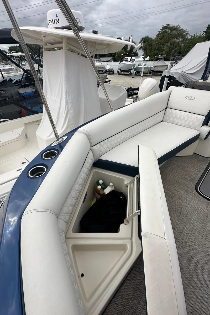 Slide: The Image of 2022 Harris Crowne SL 250 boat with open storage compartment and cushioned seating. - 34