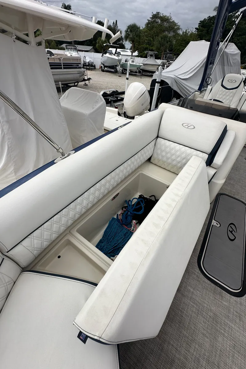 Slide: The Image of 2022 Harris Crowne SL 250 boat with open storage compartment and white seating. - 35