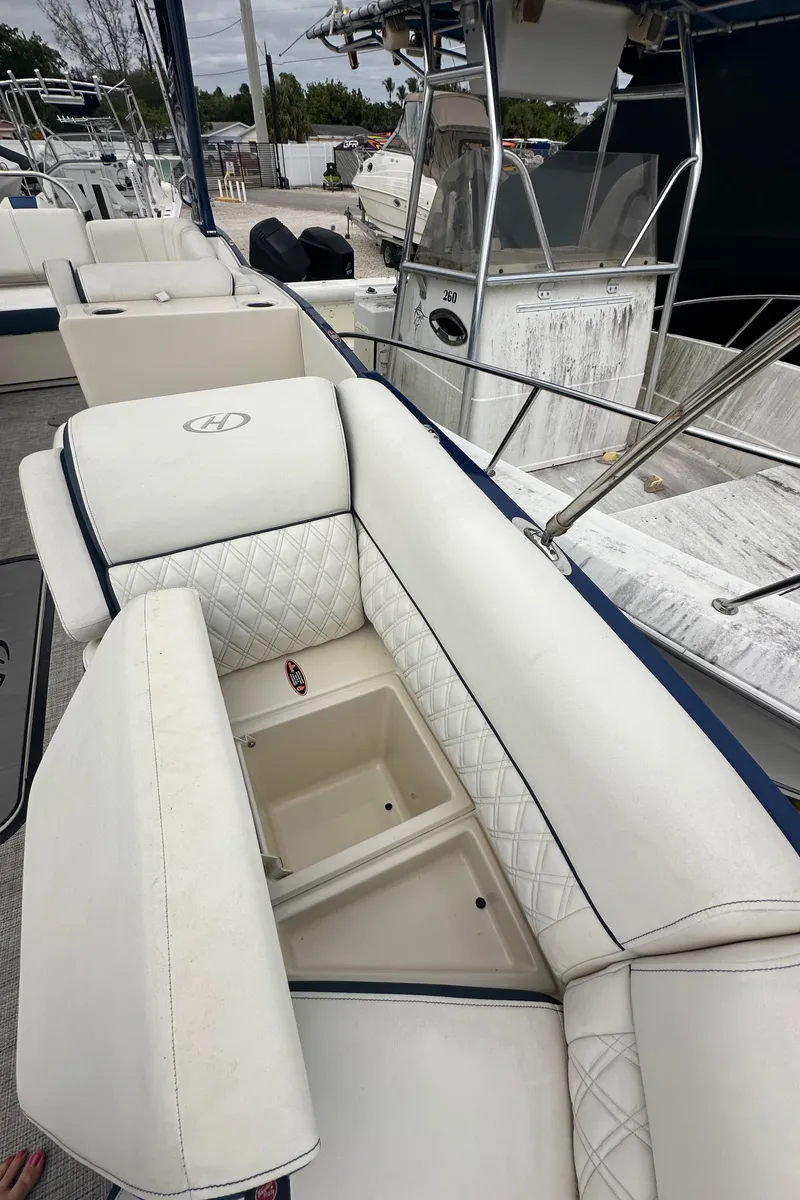 Slide: The Image of 2022 Harris Crowne SL 250 boat with luxurious white seating and storage compartments. - 39
