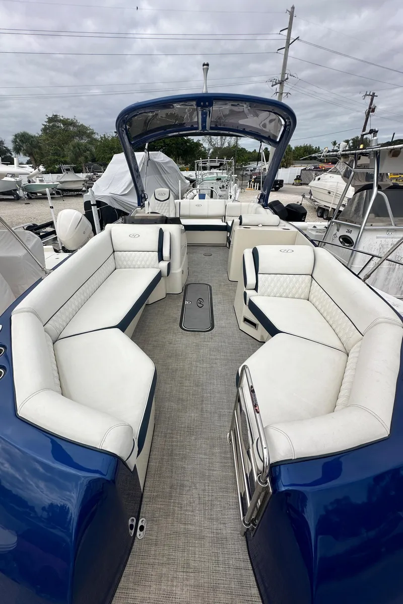 Slide: The Image of 2022 Harris Crowne SL 250 boat with white seating and blue exterior, docked outdoors. - 45