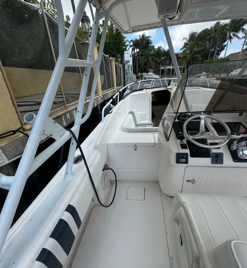 Slide: The Image of 2000 Intrepid 366 boat with white interior, docked near palm trees. - 11