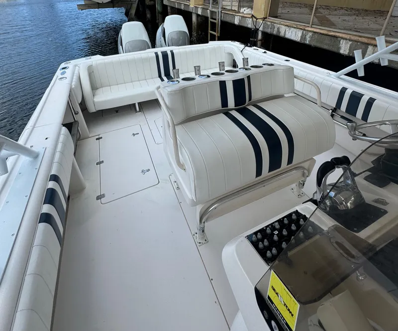 Slide: The Image of 2000 Intrepid 366 boat interior with white and blue seating, docked by the water. - 15