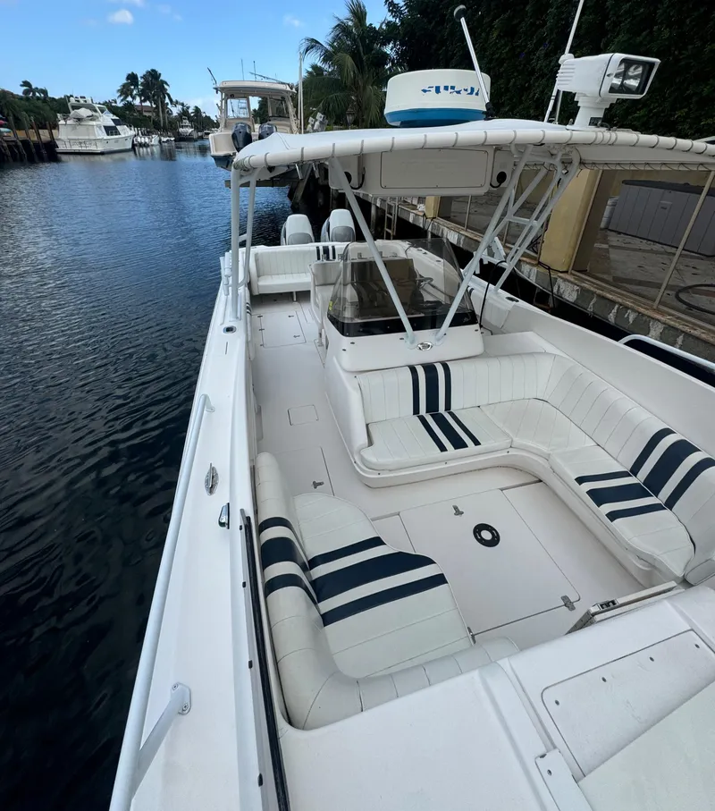 Slide: The Image of 2000 Intrepid 366 boat with white seating, docked in a serene marina. - 17