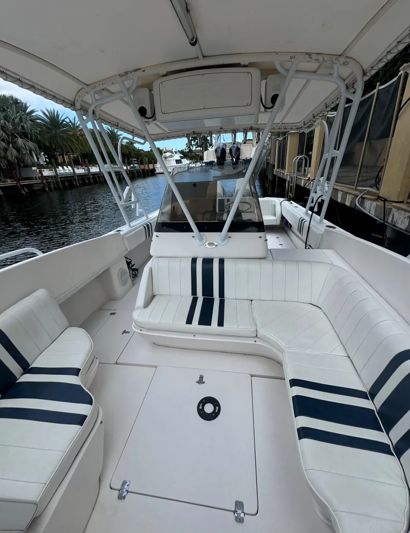Slide: The Image of 2000 Intrepid 366 boat interior with white and navy seating, docked by a canal. - 18