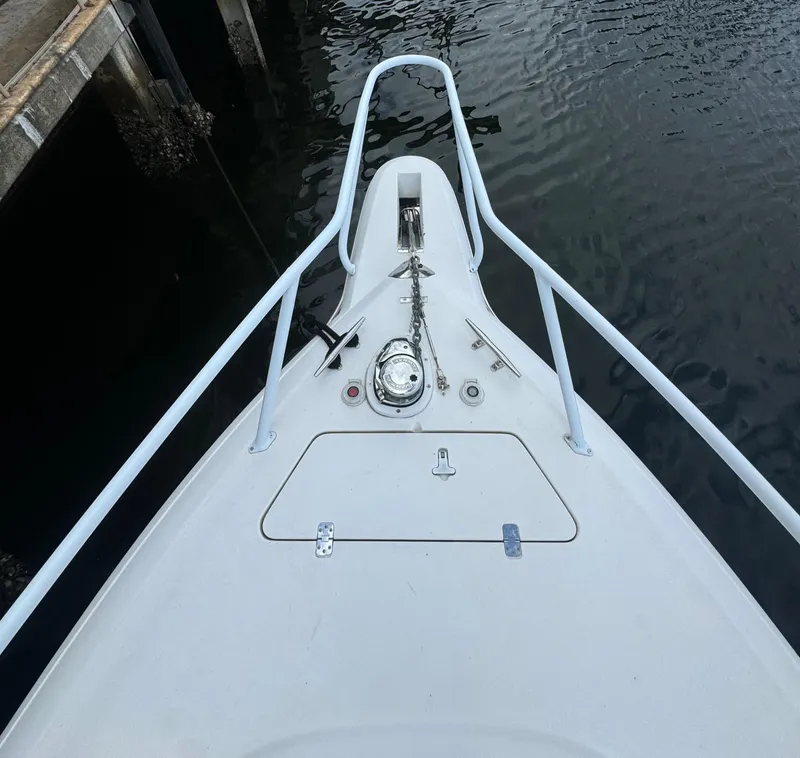 Slide: The Image of Bow of a 2000 Intrepid 366 boat with anchor and railing, docked by water. - 23
