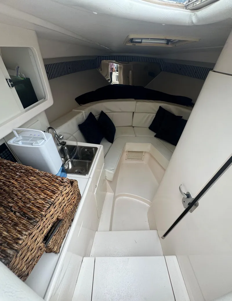 Slide: The Image of Interior of a 2000 Intrepid 366 boat with cozy seating and compact kitchenette. - 26