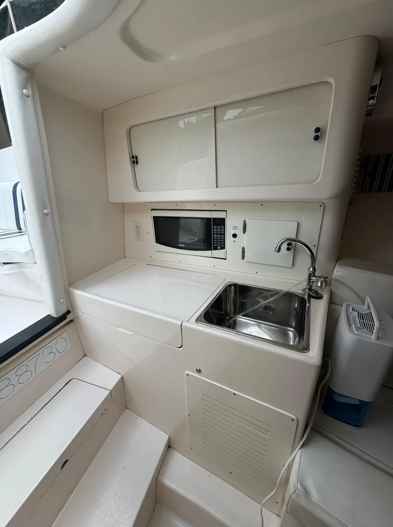 Slide: The Image of Compact kitchen area in a 2000 Intrepid 366 boat with sink and microwave. - 27