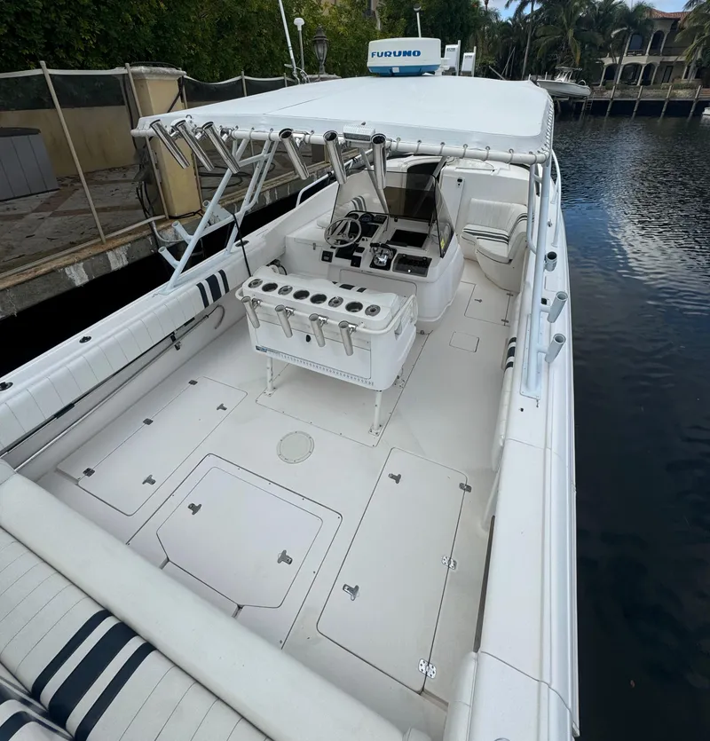 Slide: The Image of 2000 Intrepid 366 boat with spacious deck and seating, docked by a canal. - 6