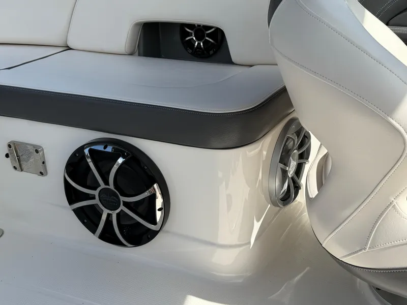 Slide: The Image of 2016 Chaparral 244 boat interior with white seating and built-in speakers. - 11