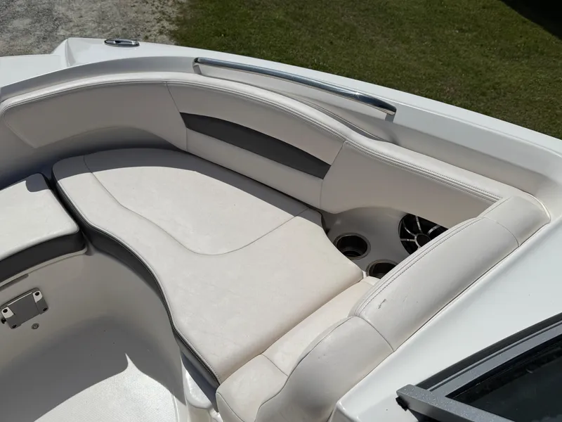 Slide: The Image of 2016 Chaparral 244 boat interior with white cushioned seating and cup holders. - 7