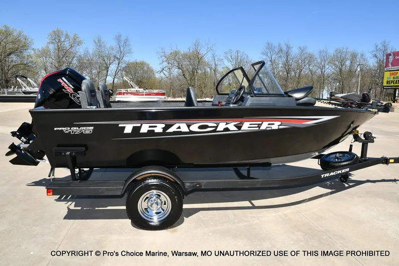 Slide: The Image of 2025 Tracker Pro Guide V-175 Combo boat on trailer, parked outdoors. - 15