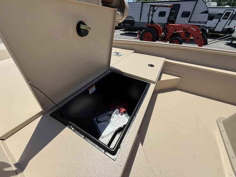 Slide: The Image of Open storage compartment on 2025 G3 Bay 20 boat, with RV and tractor in background. - 8