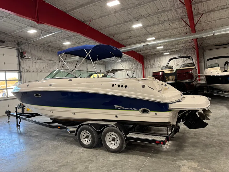 Slide: The Image of 2004 Chaparral 260 SSi boat with blue hull on trailer in indoor storage. - 3