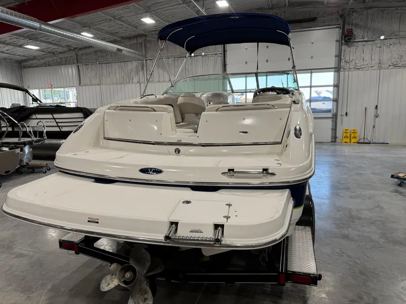 Slide: The Image of 2004 Chaparral 260 SSi boat in indoor storage, rear view with blue canopy. - 5