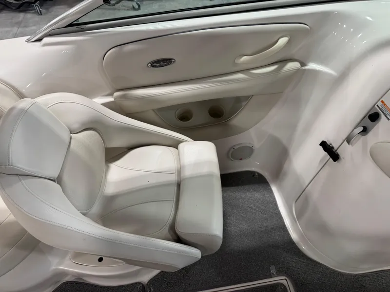 Slide: The Image of 2004 Chaparral 260 SSi boat interior with white seating and cup holders. - 8