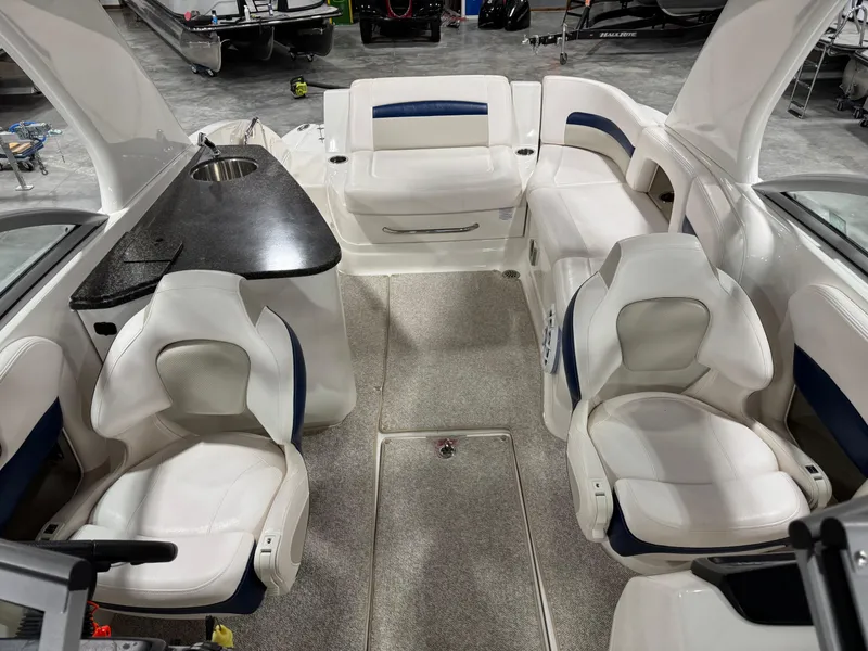 Slide: The Image of 2010 Chaparral 264 Sunesta boat interior with white seating and a black countertop. - 13