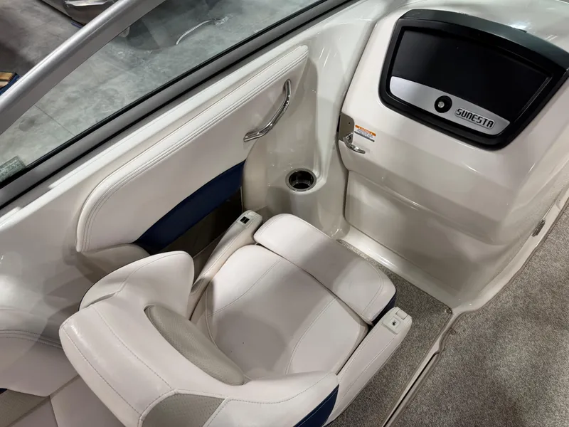 Slide: The Image of 2010 Chaparral 264 Sunesta boat interior with white seating and storage compartment. - 15