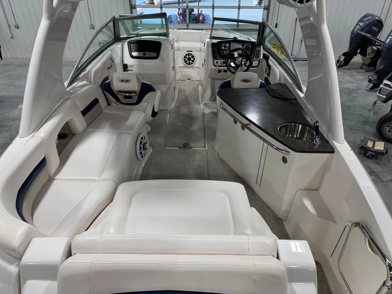 Slide: The Image of 2010 Chaparral 264 Sunesta boat interior with white seating and kitchenette. - 8