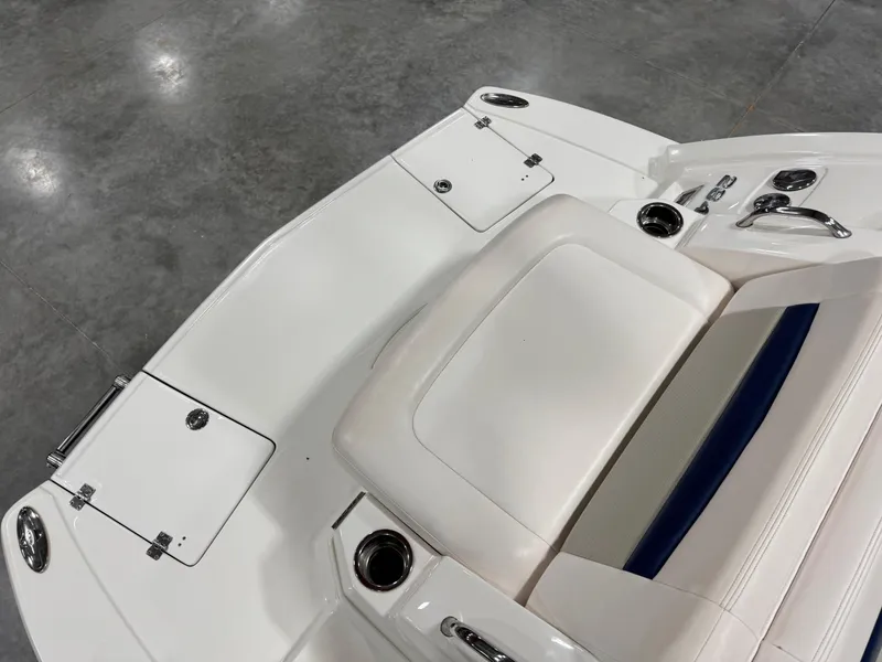 Slide: The Image of 2010 Chaparral 264 Sunesta boat interior with white seating and storage compartments. - 9