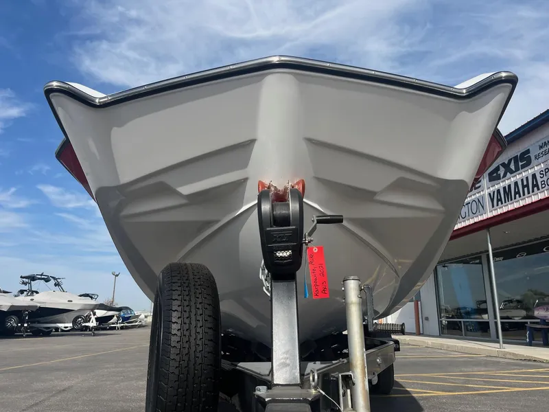 Slide: The Image of 2021 Axis A22 boat on trailer, parked outside dealership under blue sky. - 12