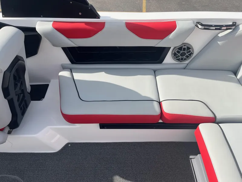 Slide: The Image of 2021 Axis A22 boat interior with red and gray seating, speaker, and handle. - 21