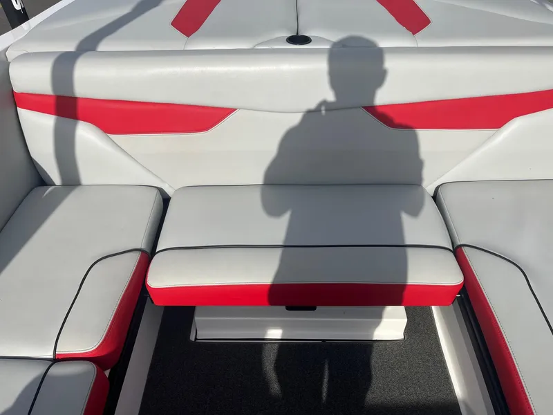 Slide: The Image of 2021 Axis A22 boat interior with red and white seating, shadow visible. - 23