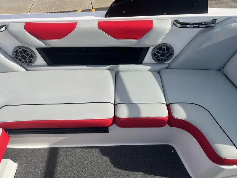 Slide: The Image of 2021 Axis A22 boat interior with red and gray seating, featuring built-in speakers. - 25