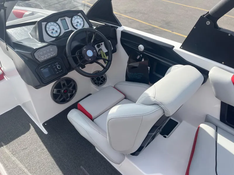 Slide: The Image of 2021 Axis A22 boat interior with steering wheel, gauges, and seating. - 27