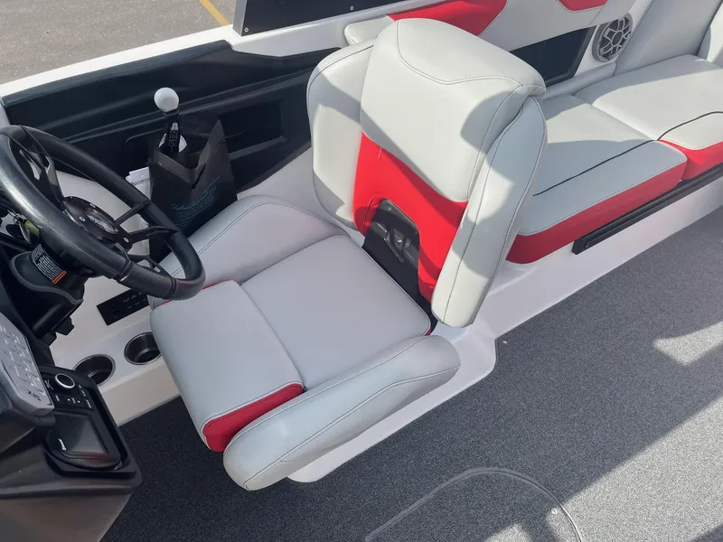 Slide: The Image of 2021 Axis A22 boat interior with red and gray seating, steering wheel, and control panel. - 28