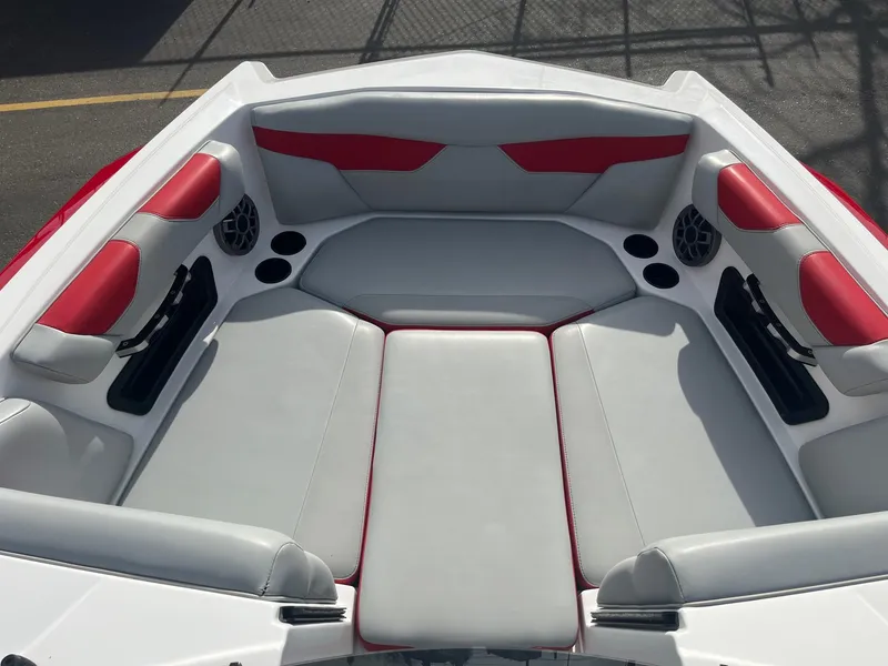 Slide: The Image of 2021 Axis A22 boat interior with red and gray seating, cup holders, and speakers. - 31