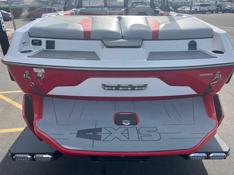 Slide: The Image of 2021 Axis A22 boat, red and white, rear view with swim platform and seating. - 7