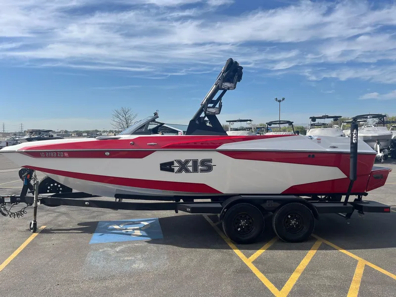Slide: The Image of 2021 Axis A22 boat in red and white on a trailer, parked in a lot. - 9
