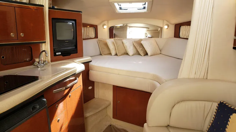 Slide: The Image of Interior of 2002 Sea Ray 300 Sundancer with cozy bed, kitchenette, and TV. - 14
