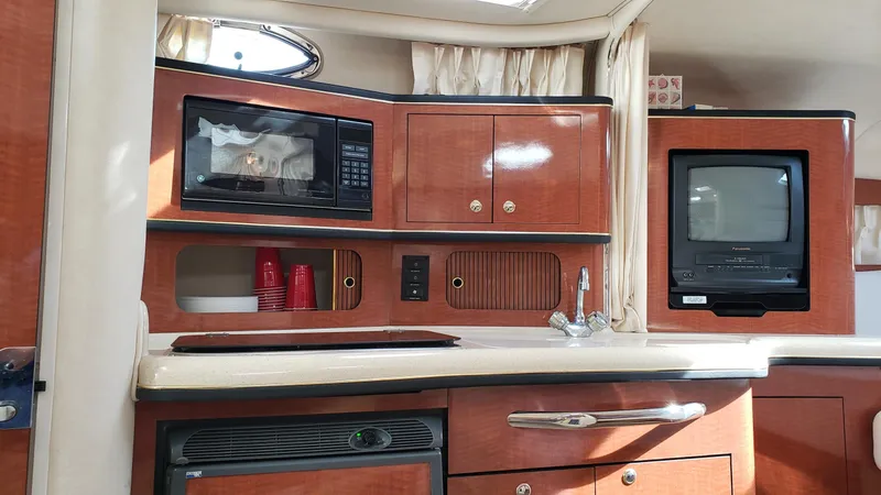 Slide: The Image of Interior of 2002 Sea Ray 300 Sundancer with microwave, TV, and wooden cabinetry. - 19